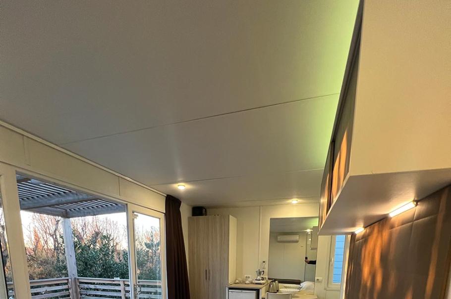 Camera moderna con letto matrimoniale e terrazza, arredamento semplice e luminoso.