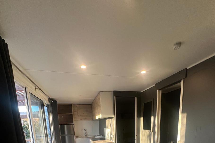 Moderno appartamento con cucina, tavolo da pranzo, divano verde e bagno.