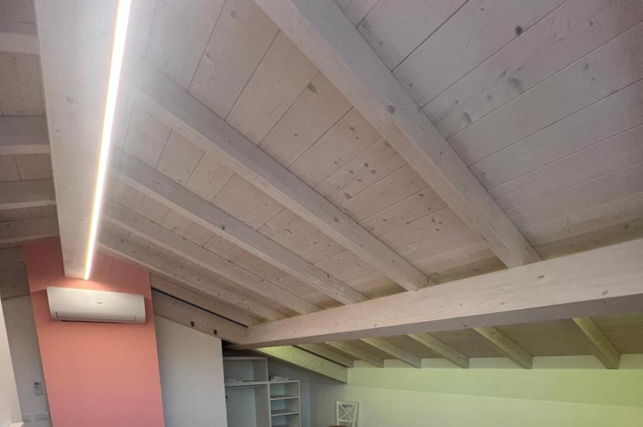 Camera con letto matrimoniale, soffitto in legno, aria condizionata e scrivania.